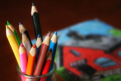 Close-up of colorful pencils in desk organizer on table
