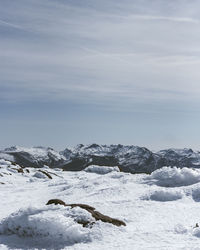 Snow covered land against sky