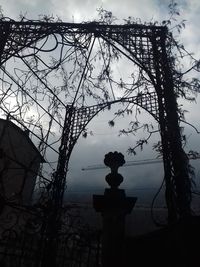 Low angle view of silhouette statue against bare trees