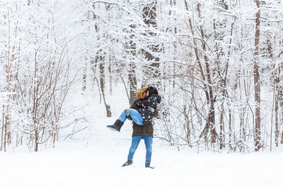 Full length of woman standing on snow covered land