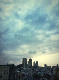 Cityscape against cloudy sky