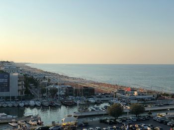 High angle view of city by sea against clear sky