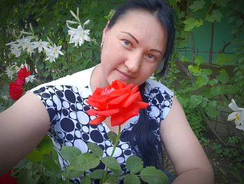 Portrait of woman holding red flower