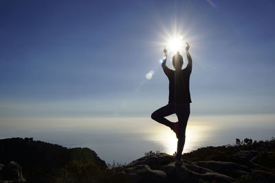 Low angle view of silhouette woman standing against sky during sunset