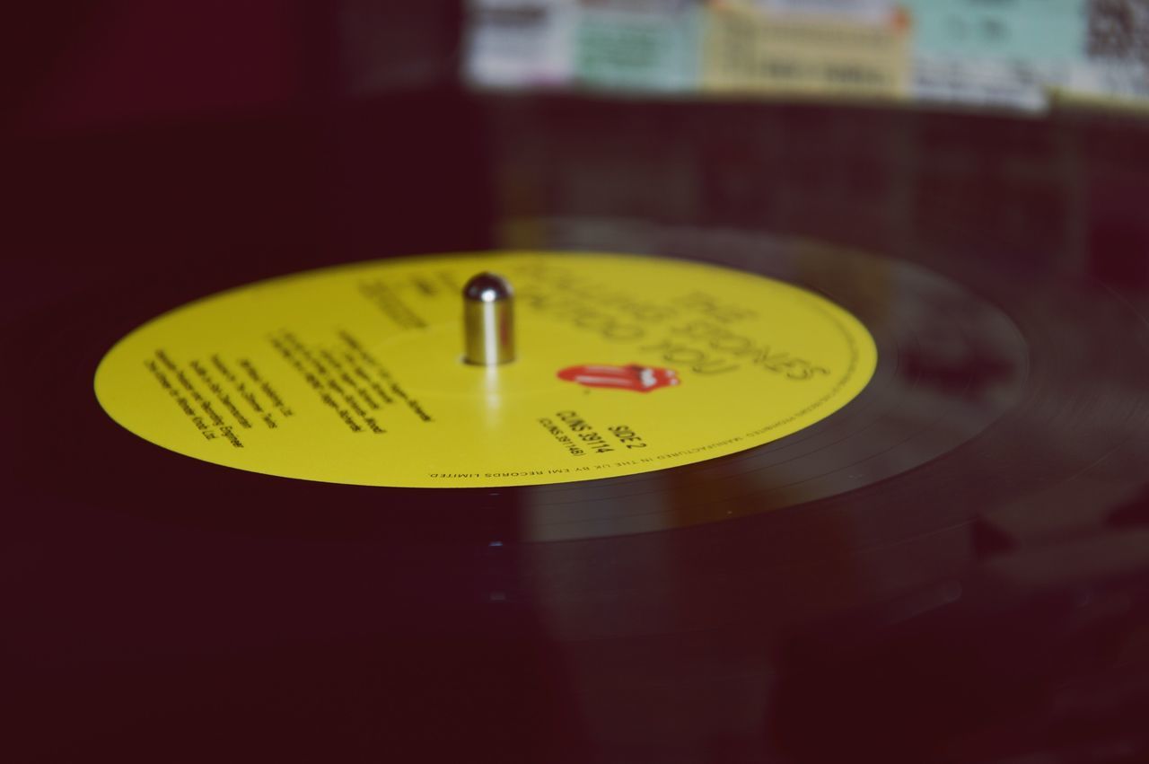 indoors, close-up, yellow, communication, illuminated, text, circle, focus on foreground, western script, single object, no people, still life, number, selective focus, lighting equipment, reflection, time, table, night, technology