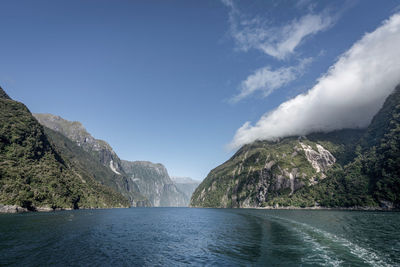 Scenic view of lake by mountains against sky