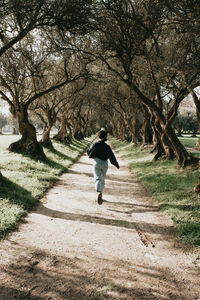 Rear view of man walking on footpath