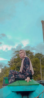 Portrait of smiling young woman against sky