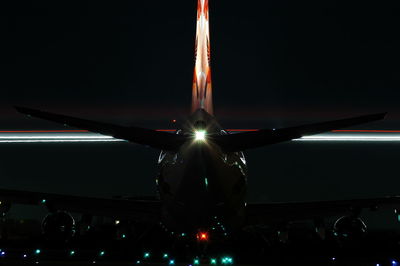 Illuminated airplane against sky at night