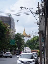 Cars on road against sky in city