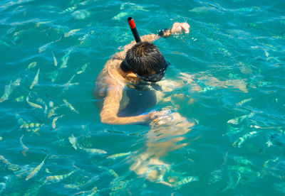 High angle view of boy swimming in sea