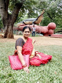 Portrait of smiling woman sitting on plants