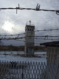 Metal fence against sky in city