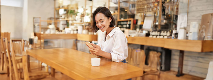 Portrait of young woman standing in cafe