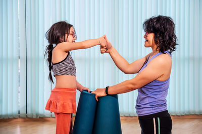 Side view of a girl standing against the wall