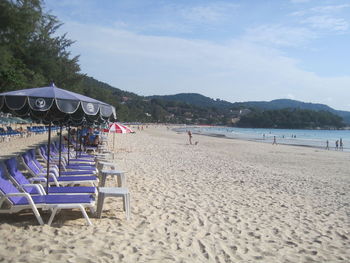 Chairs on beach against sky