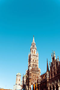 Low angle view of new town hall against clear blue sky at marienplatz in city