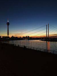 View of bridge over river at sunset