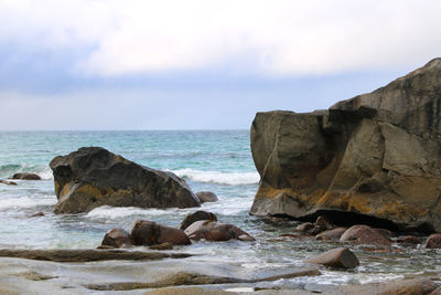 Rocks on beach against sky