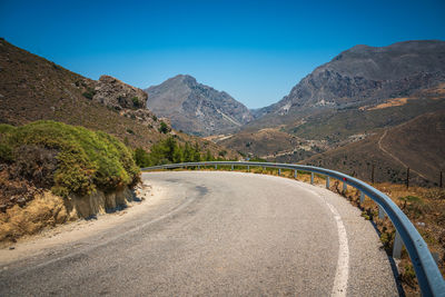 Scenic view of road into mountains against sky