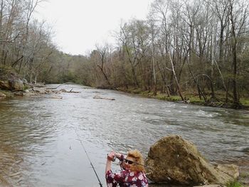 People on river amidst trees in forest