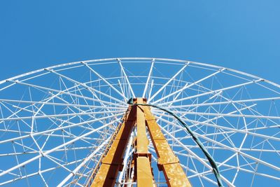 Low angle view of ferris wheel against blue sky