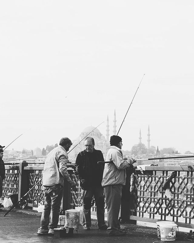 men, clear sky, lifestyles, rear view, leisure activity, standing, copy space, full length, casual clothing, person, built structure, togetherness, railing, architecture, building exterior, sky, day, walking