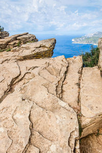 Rock formation on beach against sky