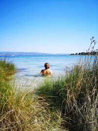 Rear view of man looking at sea against sky