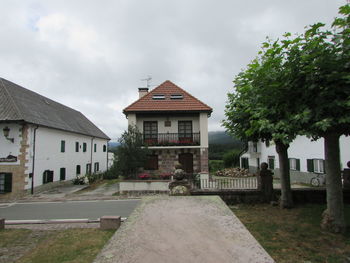 Houses by building against sky