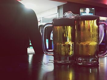 Close-up of beer glasses on table