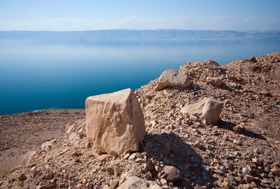 Scenic view of rocks on beach against sky