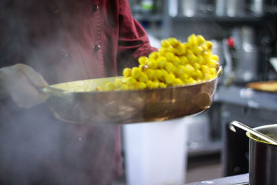 Midsection of person preparing food in kitchen