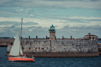 Boats in sea with buildings in background