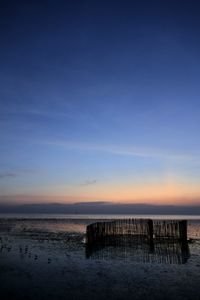 Pier on sea against sky at sunset