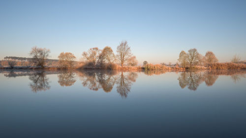 Scenic view of lake against clear blue sky