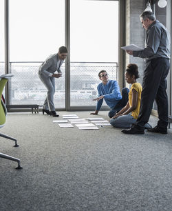 Businesspeople looking at documents on office floor