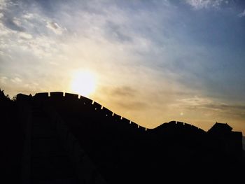 Low angle view of silhouette buildings against sky