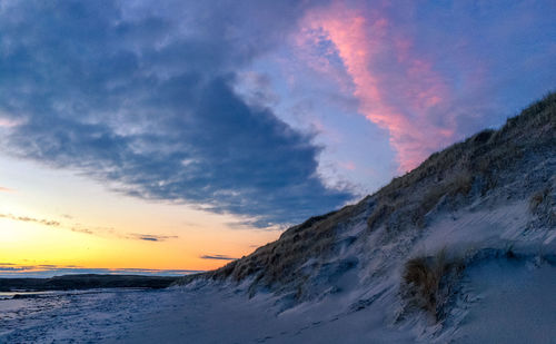 Scenic view of snow against sky during sunset