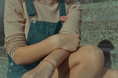 Low section of woman sitting outdoors