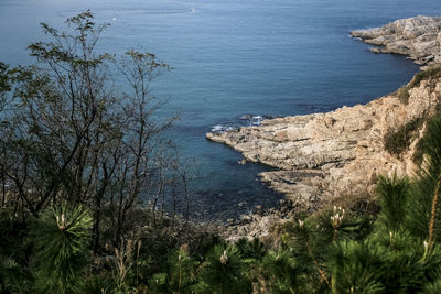 Scenic view of cliff by sea against sky