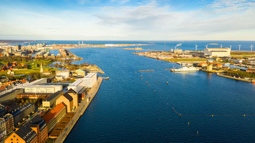 High angle view of city by sea against sky