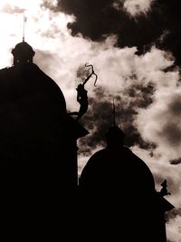 Low angle view of silhouette man standing against sky