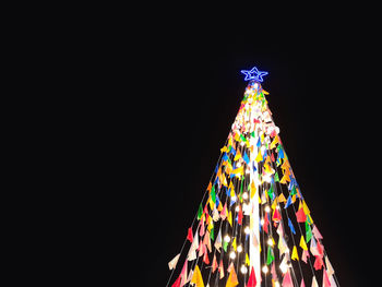 Low angle view of illuminated christmas tree against sky at night