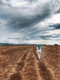 Rear view of person walking on field