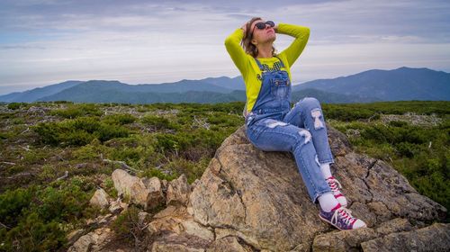 Full length of woman on rock against sky