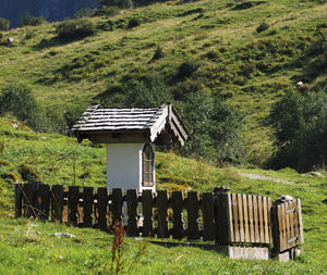 Gazebo on field against trees and plants