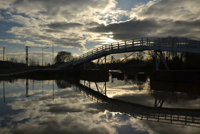 Bridge over river against sky during sunset