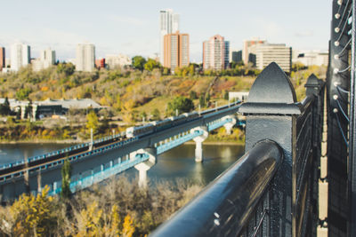Bridge over river in city against sky