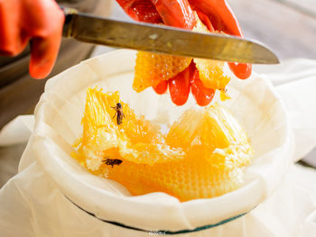 Cropped hands of person removing honey from beehive